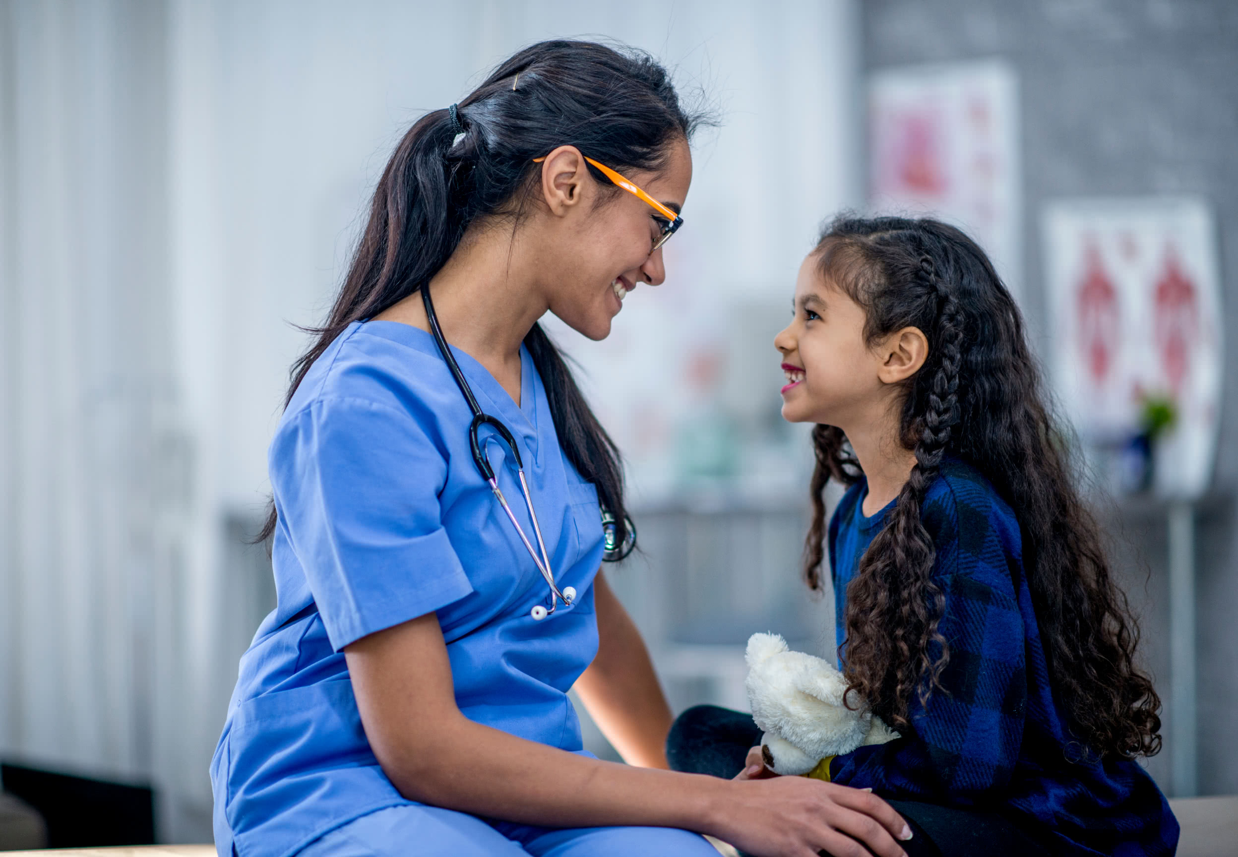 Care provider with young patient, both smiling